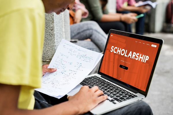 PS student using a laptop to browse college scholarships