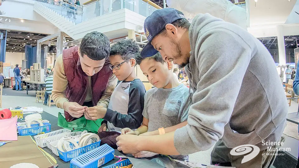 Students at a science museum exhibit table