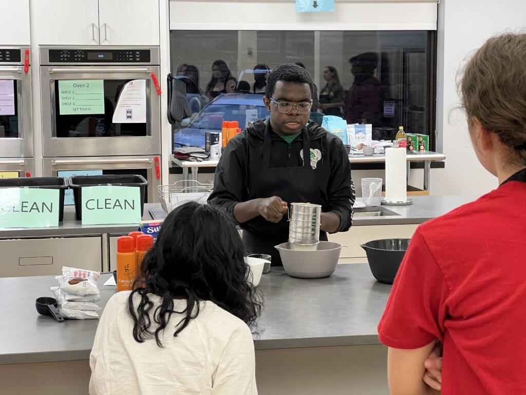 PS student leading a baking class in our institute space