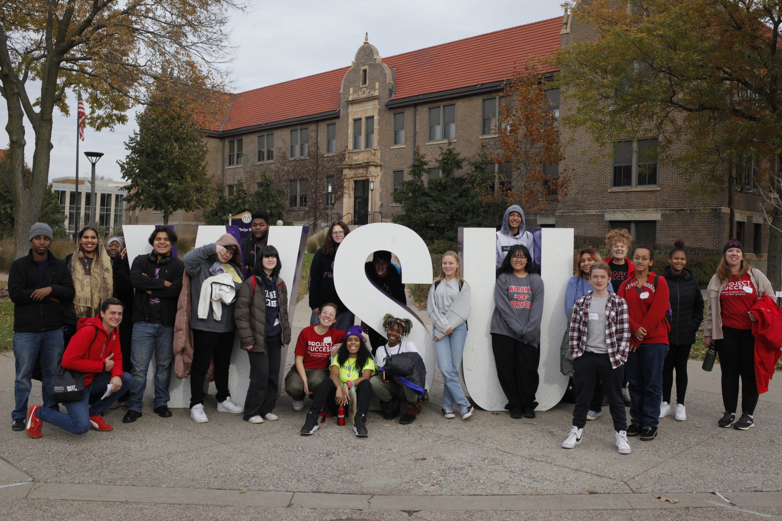 PS students on a college tour in front of the Winona State University sign