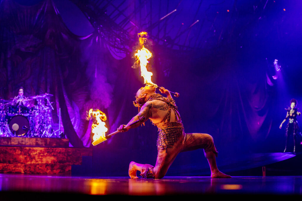 Cirque du Soleil performer breathing fire on stage