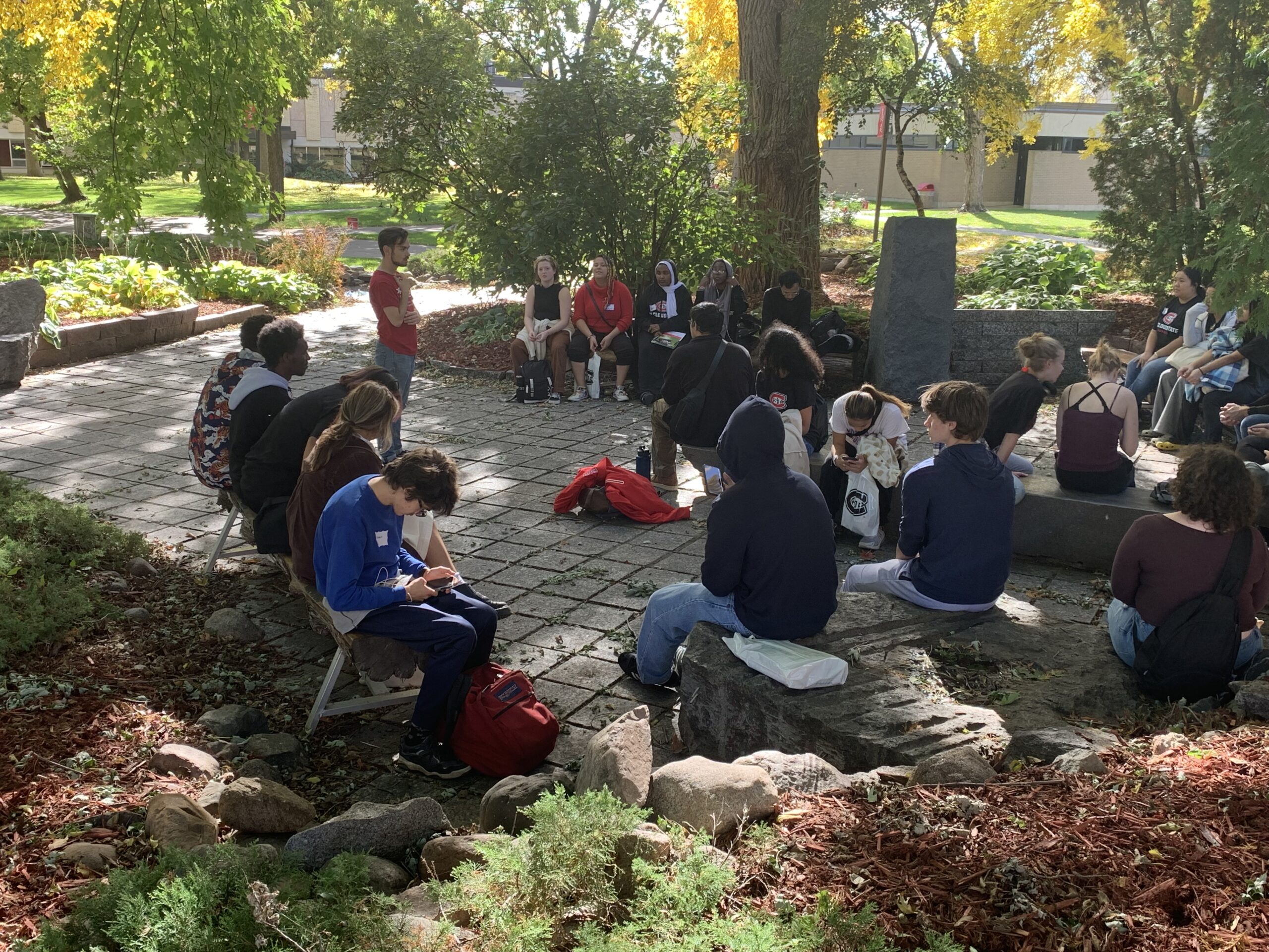 PS students gather around a staff member on a patio outside