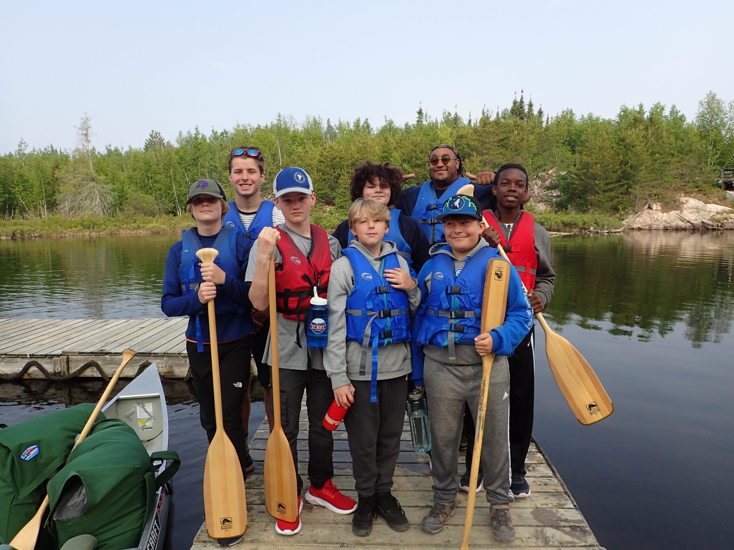 Darrow with a group of students standing on a dock with students in the BWCA.