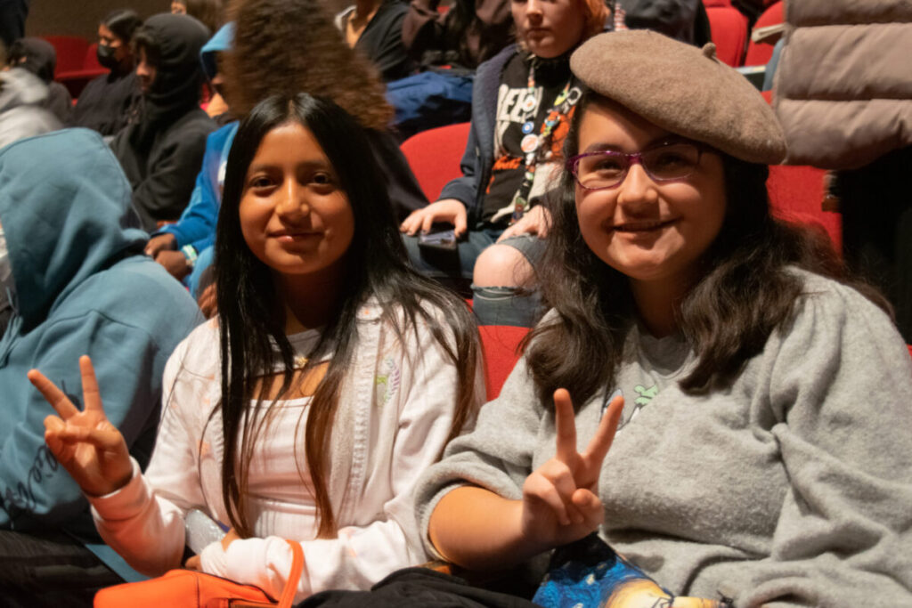 two PS students sitting in theater seats for a performance