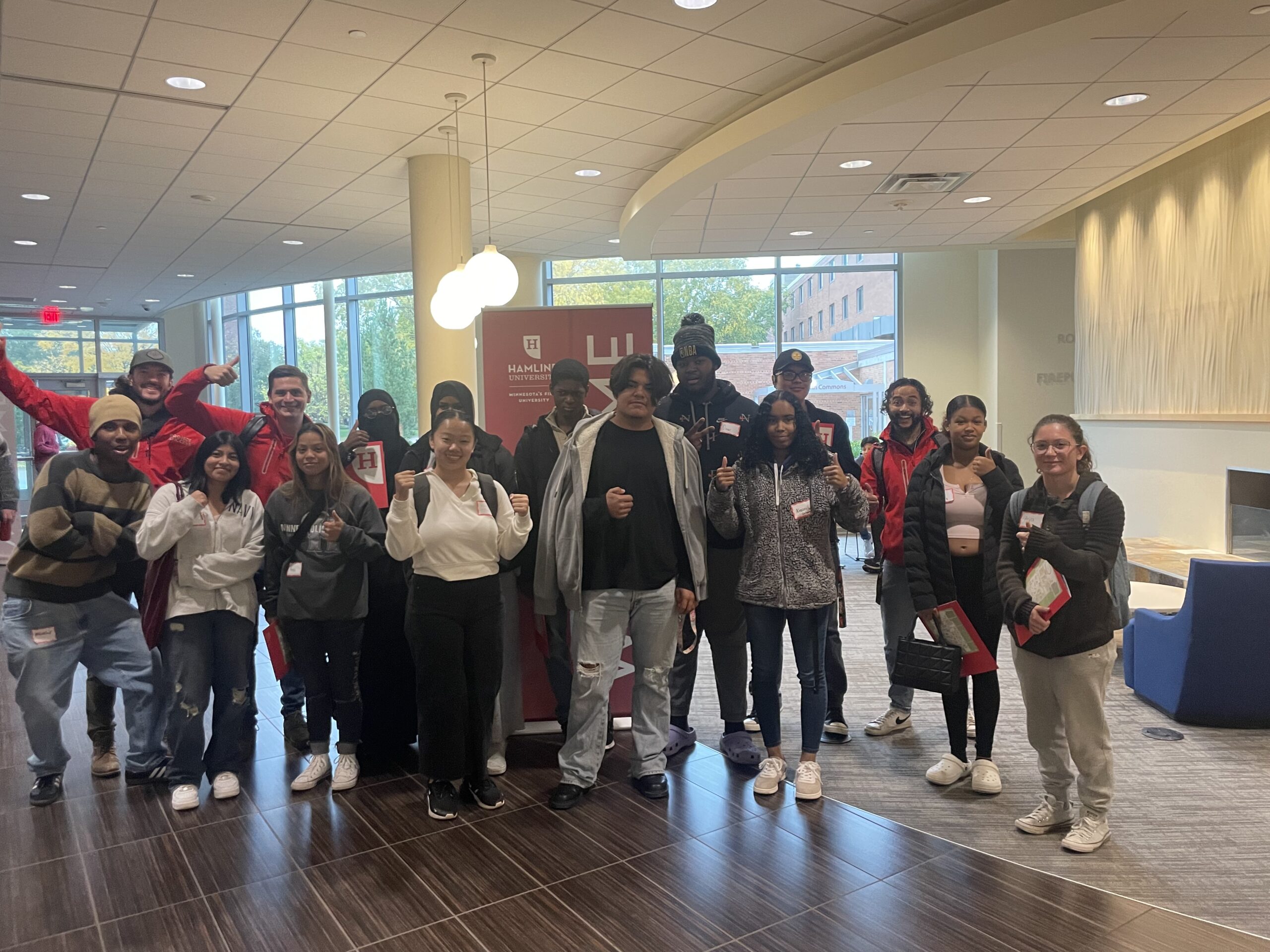 Students and PS staff posing with a Hamline sign