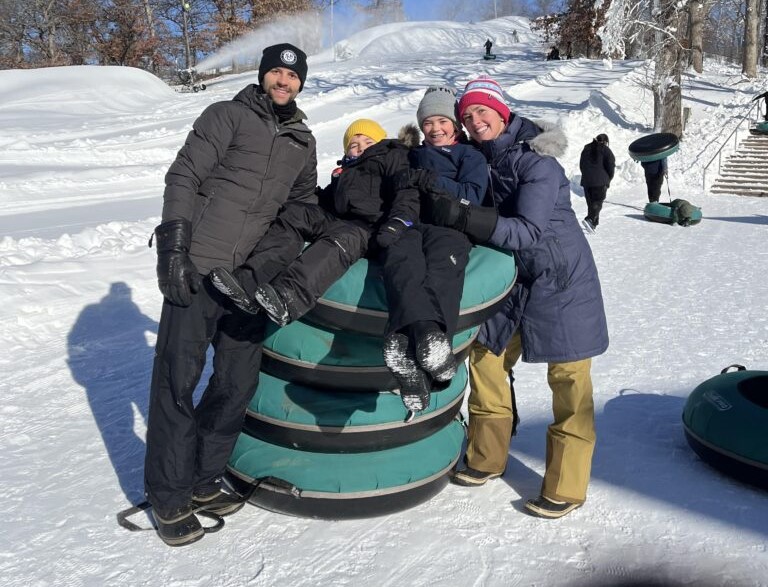 Family posing with snow tubes at Winter Adventure Day