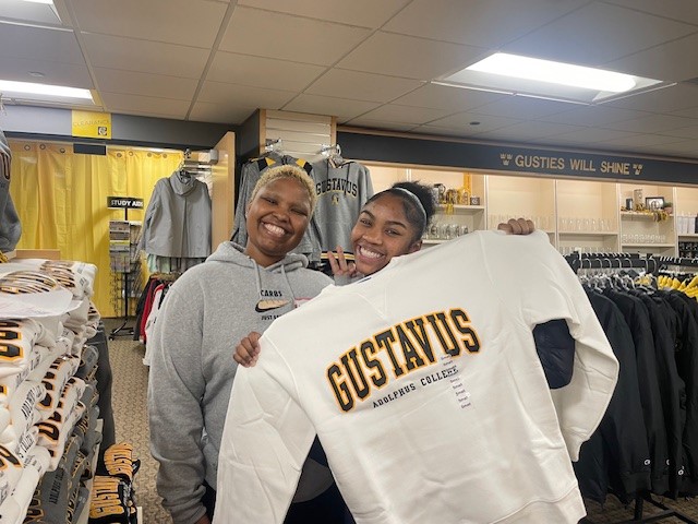 Two PS Students holding up a gustavus sweatshirt